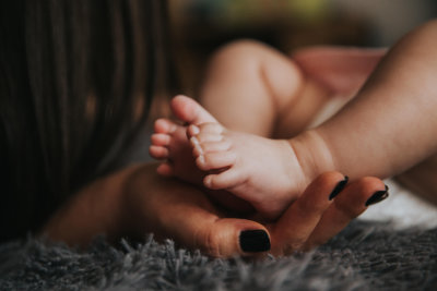a mother's hand holding the feet of a child
