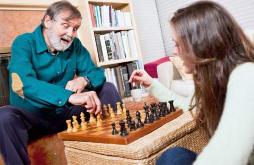 elderly man and a woman playing chess