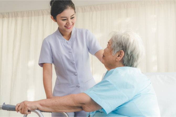 caregiver smiling and facing at a elderly woman